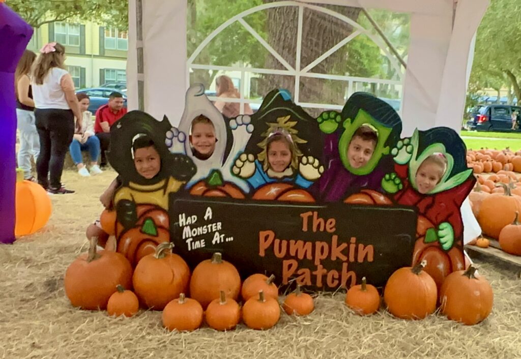 Kids in costumes at a pumpkin patch.